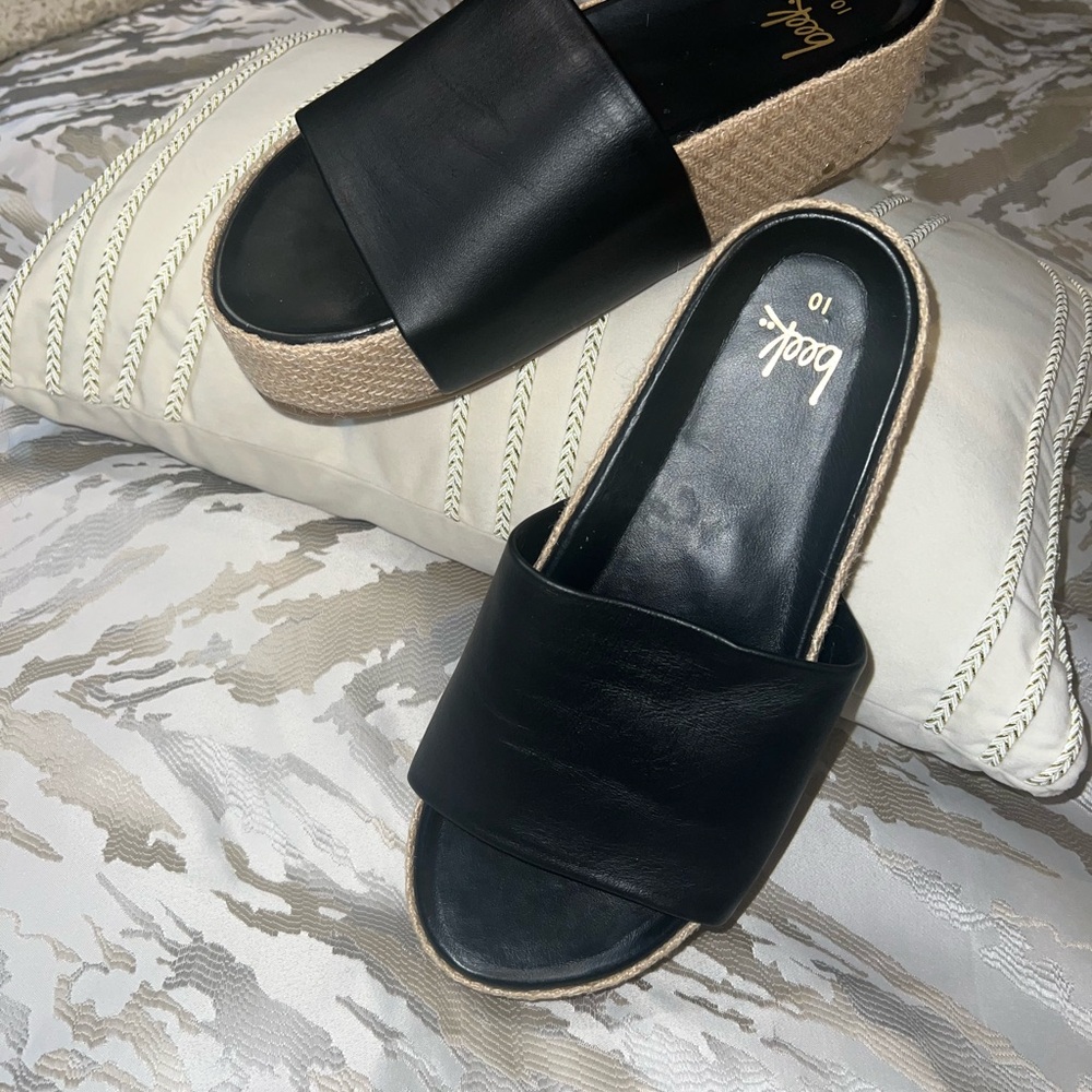 Beek black leather slides.
